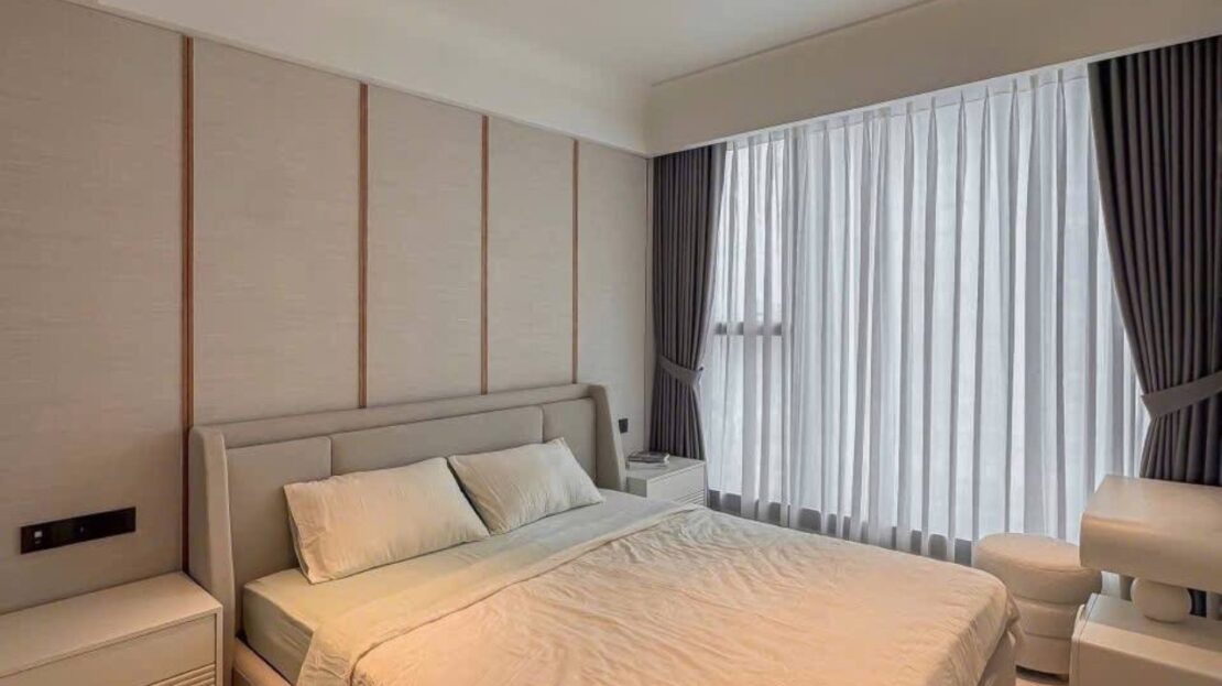 Bedroom with panelled headboard wall and sheer curtains, Grand Marina Saigon 1BR