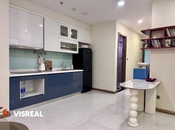 Navy and white kitchen with black fridge and round breakfast table, Vinhomes Central Park 1BR