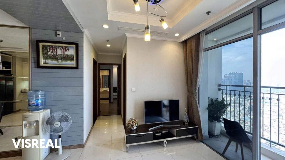Living room with TV and balcony door open to city views, Vinhomes Central Park 2-bedroom