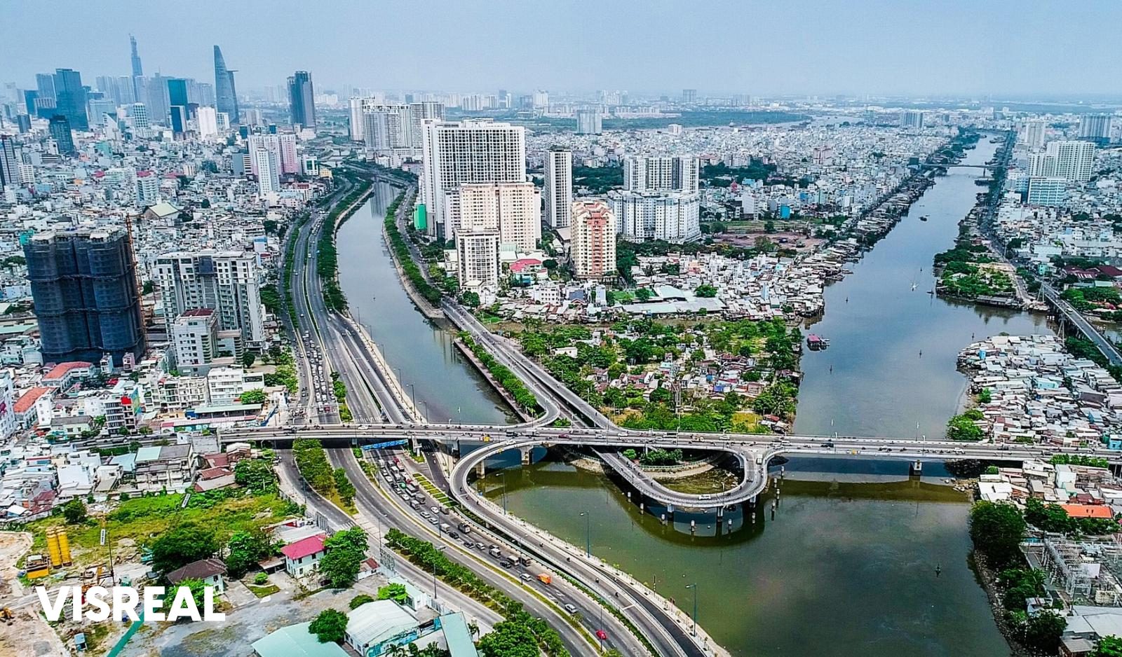 Aerial view of canals, bridges and apartment towers in the old District 4, with the District 1 skyline behind